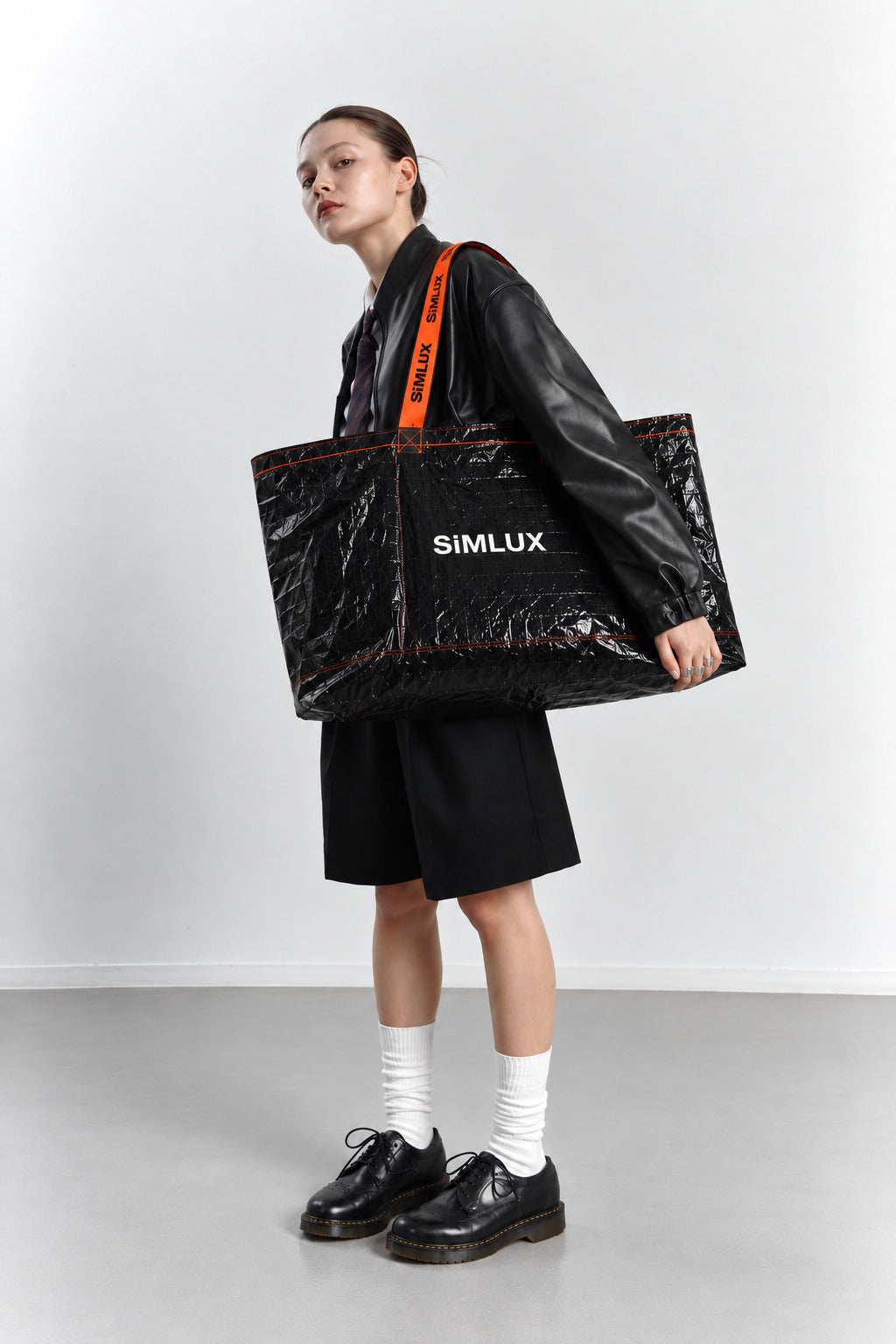 Model in a black leather jacket carrying a SiMLUX Cargo Bag